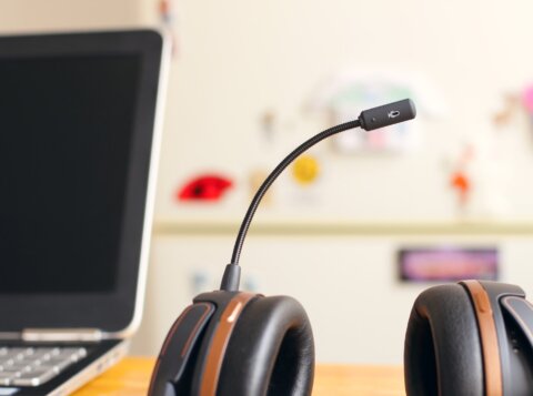 black and brown headset near laptop computer