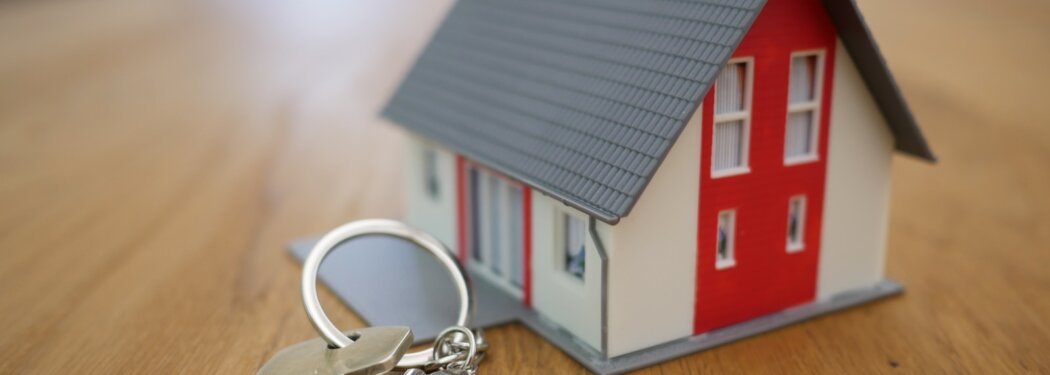 white and red wooden house miniature on brown table