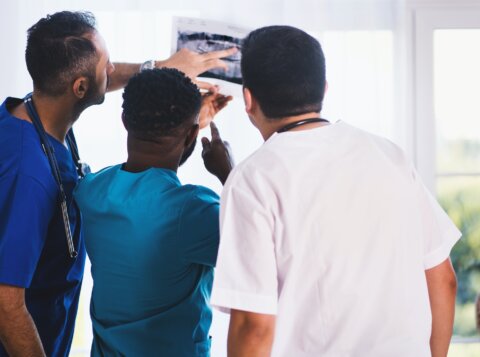 Three Person Looking at X-ray Result