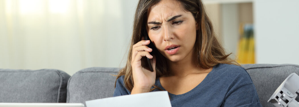woman on phone looking at paperwork