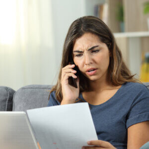 woman on phone looking at paperwork