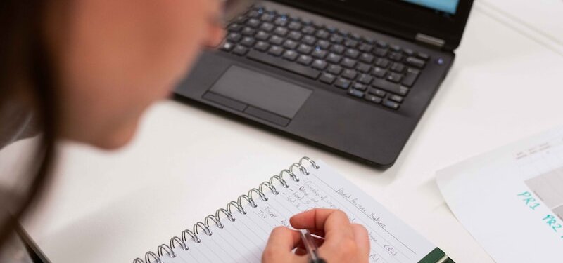 person writing on white paper