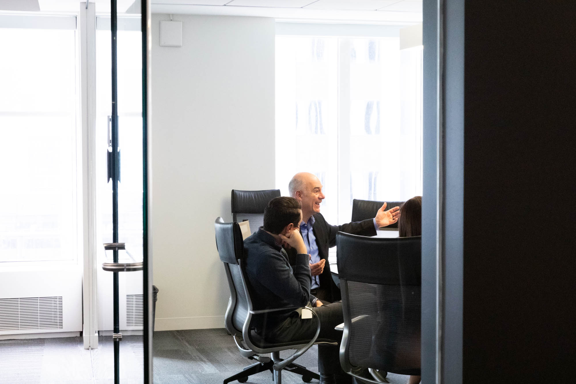Two men sitting at a conference table while talking