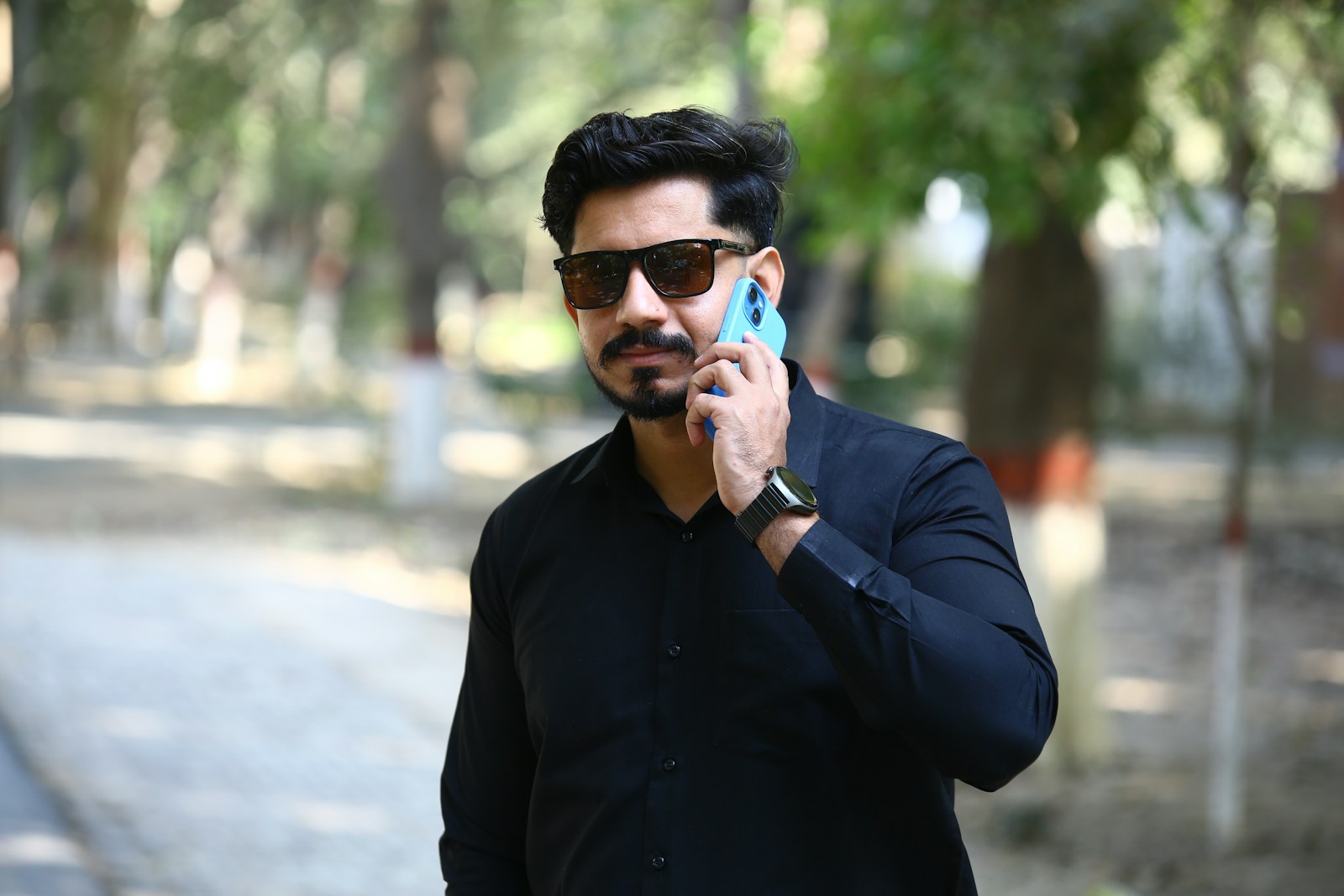 Man in sunglasses talking on a cell phone outdoors