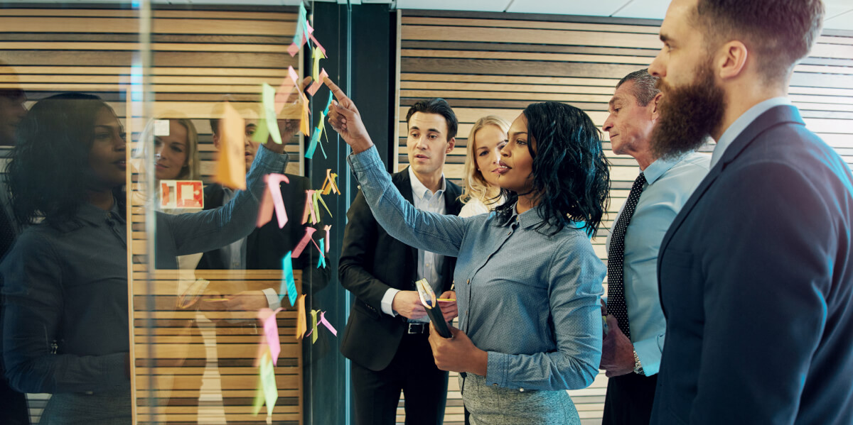 a group of business professionals putting sticky notes on the wall