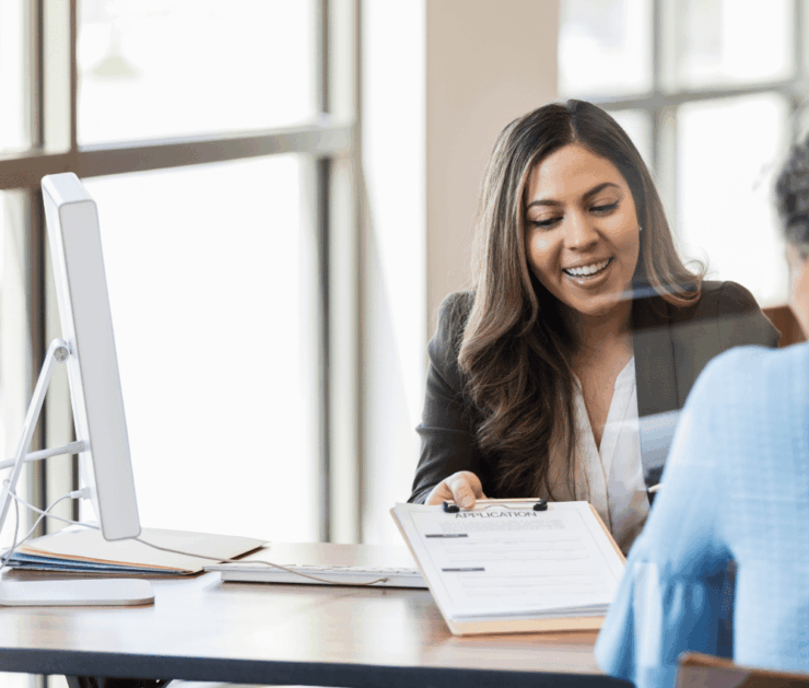 woman smiling holding a clipboard for a customer