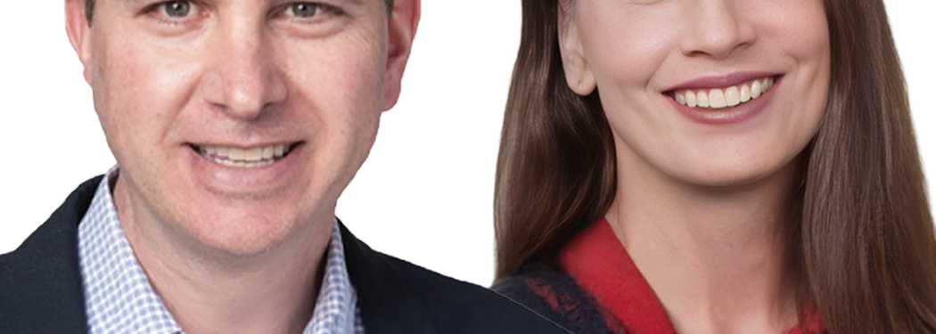 Two people stand side by side, a smiling man in a blazer and a smiling woman with long hair in a red top, against a white background.