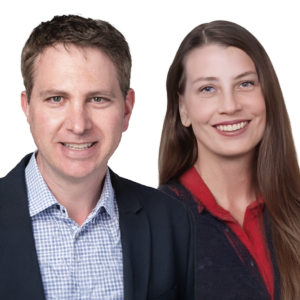 Two people stand side by side, a smiling man in a blazer and a smiling woman with long hair in a red top, against a white background.