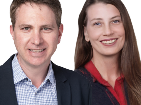 Two people stand side by side, a smiling man in a blazer and a smiling woman with long hair in a red top, against a white background.