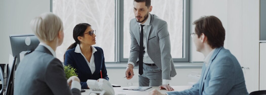 Business professionals in a meeting around a table.